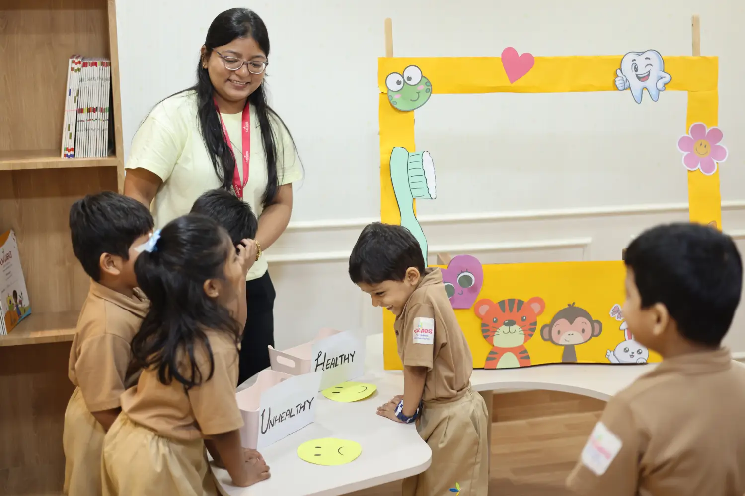 Teacher guiding a small group of children at a colourful activity board in a Williez Preschool classroom