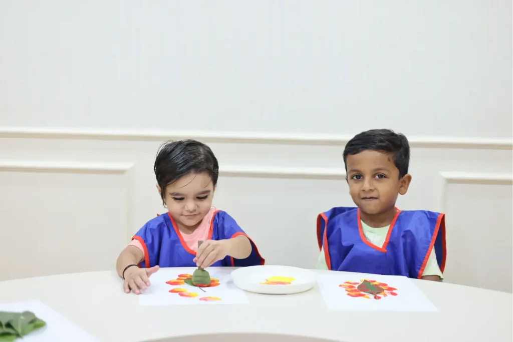 Two children in Williez aprons enjoying a healthy snack at a table