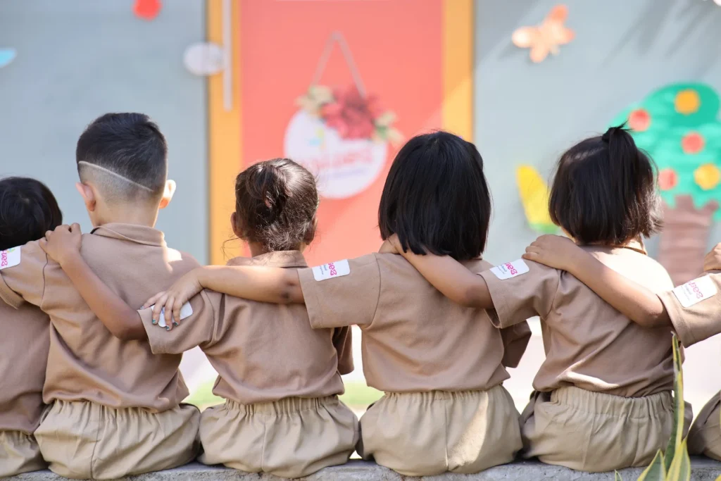 Three best friends with arms around each other at Williez Preschool, India