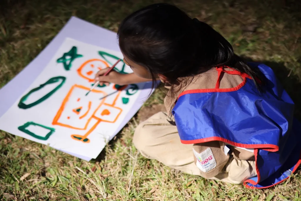 Child painting colourful shapes during art time at Williez Preschool, India