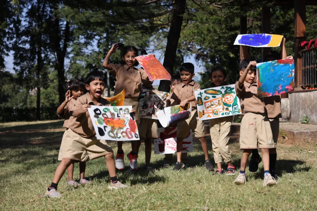 Group of children holding up their artwork at Williez Preschool, India