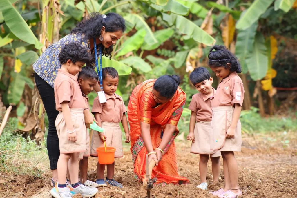 Teachers guiding children during a gardening activity at Williez Preschool, India