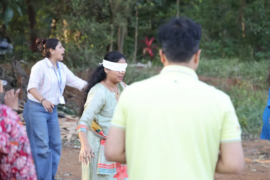 Educators guiding a child in a blindfold trust game at Williez Preschool, India